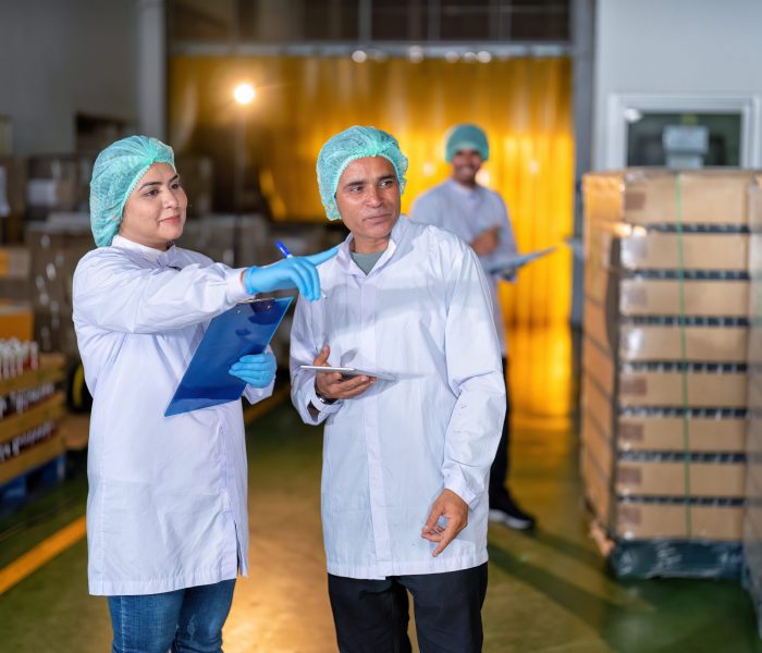 In warehouse quality control team checking drinking bottle stack on pallet before delivery